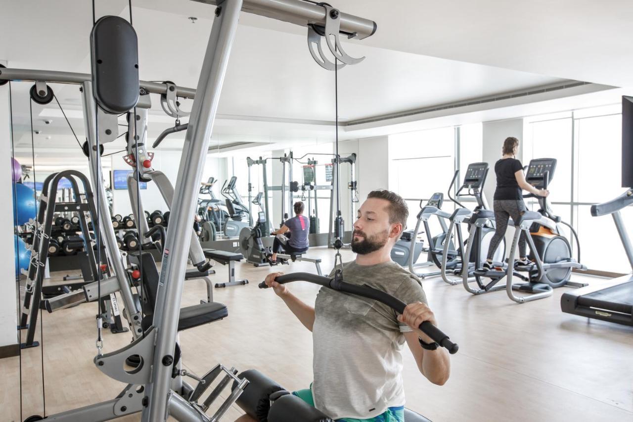 Royal M Hotel Fujairah By Gewan Экстерьер фото A man using a lat pulldown machine